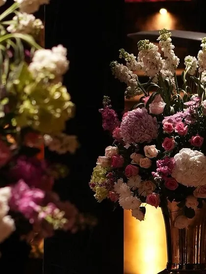 A close-up of the beautiful floral arrangements in shades of pink and white that adorned the venue, glowing under the warm lights.