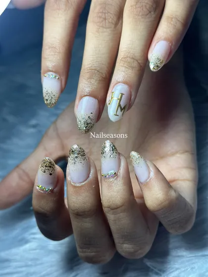 A classic bridal choice. This design features a soft nude base with a beautiful gold glitter fade and personalized initials for the couple.