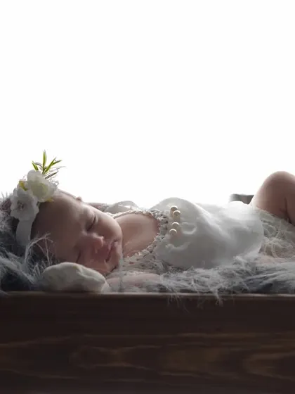 A tiny angel dreaming in a miniature wooden bed. I use a variety of props like this to create sweet, storybook scenes for your newborn's first photoshoot.