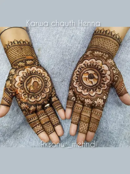 This is a classic Karwa Chauth design, with a central mandala showing the traditional scene of a woman with the sieve and pot. It’s a beautiful way to honor the rituals of the day.
