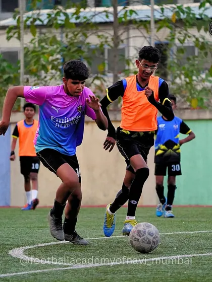 Two players from our Kalamboli Centre compete for the ball during a training match. The use of bibs helps organize teams for tactical drills.
