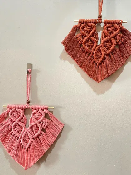 A pair of mini macrame wall hangings in warm shades of rust and pink. These smaller pieces are perfect for adding a touch of boho style to a narrow wall or as part of a larger gallery.