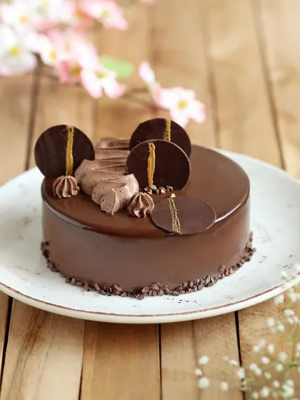 A royal upgradation to our chocolate collection. This is our brand new Chocolate Panacotta Praline Cake, featuring a smooth, glossy finish and elegant chocolate decorations.