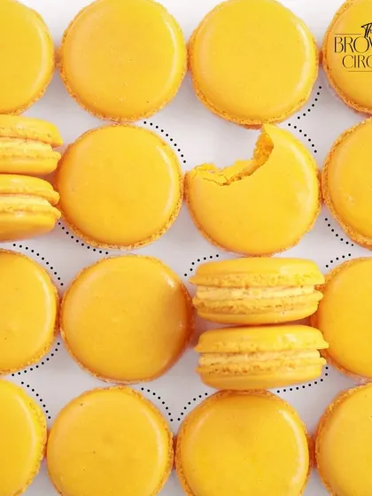 A beautiful flat lay of our Mango Macarons, showcasing their vibrant color and perfect texture.