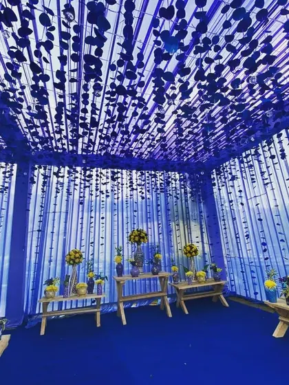An immersive photo booth or corridor created with blue fabric and hanging blue discs, offering a unique and thematic photo opportunity.