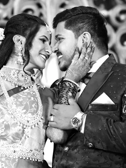A timeless black and white photo capturing a tender moment between the bride and groom during their wedding reception.