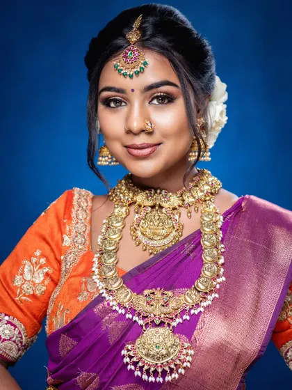A close-up portrait that captures the intricate details of the temple jewellery and the bride's radiant makeup. This is a classic and timeless bridal style.