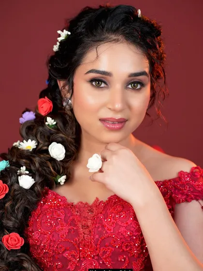 A close-up of the floral braid, showing the detail of the flowers and the soft, romantic makeup that completes this enchanting look.