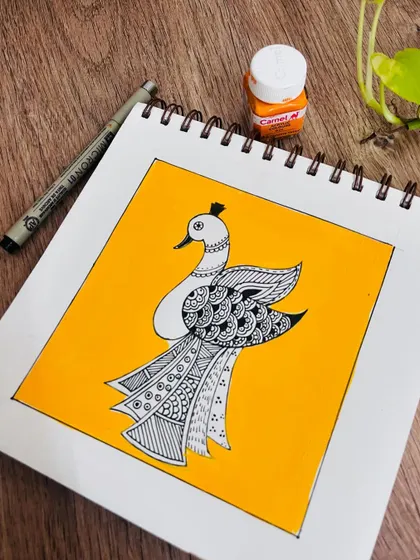 Another view of the Madhubani peacock doodle on a white sketchbook.