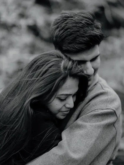A tight, emotional close-up in black and white. This image is all about the feeling of safety and comfort found in a loved one's embrace.