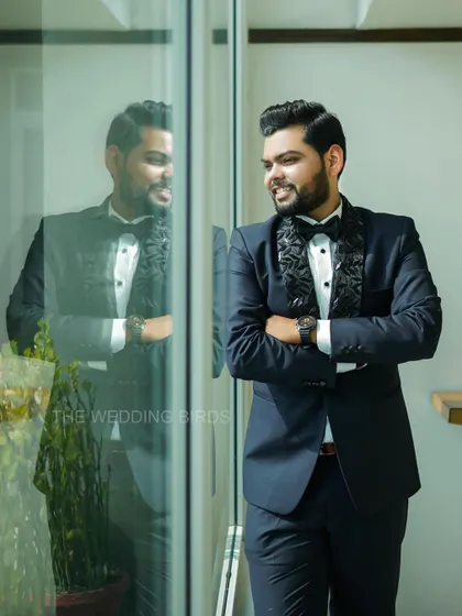 A dapper groom ready for his engagement night. This portrait captures his confident smile and sharp style, with his reflection adding a cool, modern touch.