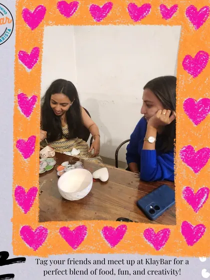 A snapshot of two friends deep in their creative process, framed by a heart. It's a place to spend quality time with loved ones.
