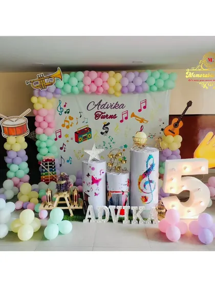 A music-themed 5th birthday party with musical note decorations, instrument cutouts, and a pastel balloon frame.