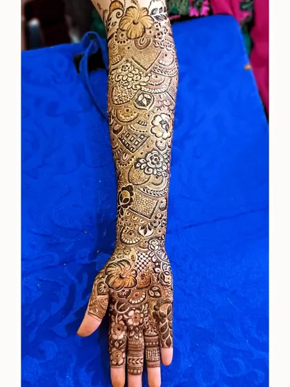 A full-sleeve mehendi design packed with detail, from tiny flowers to intricate geometric fillers.