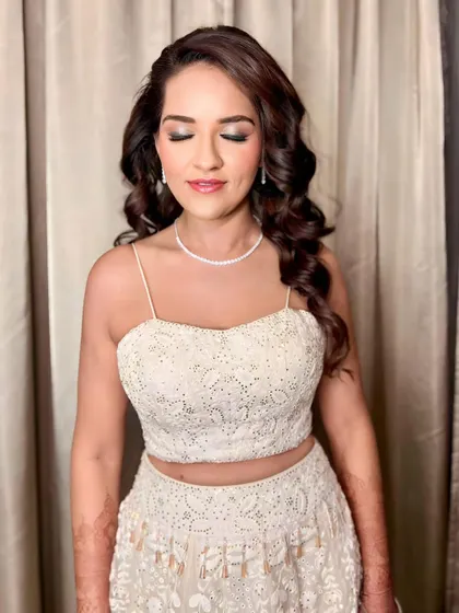 A beautiful shot of the client's soft, romantic curls for her sangeet. The makeup is focused on a shimmery eye, which pairs perfectly with the elegant hairstyle.