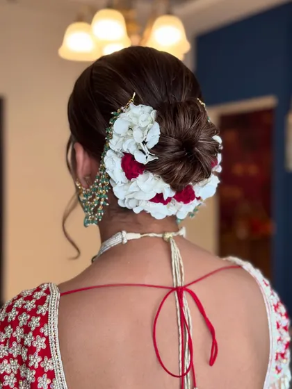 The balance of red and white flowers in this bridal updo creates a stunning visual.