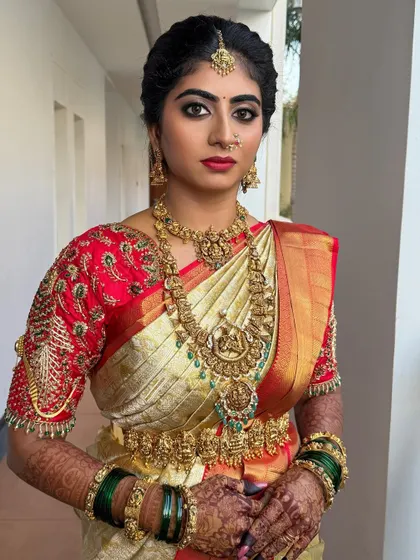 My stunning bride Nisarga on her big day. This look features a radiant soft matte finish, brown and golden eyes, and a bold bright lip shade that perfectly matches her red and cream saree.