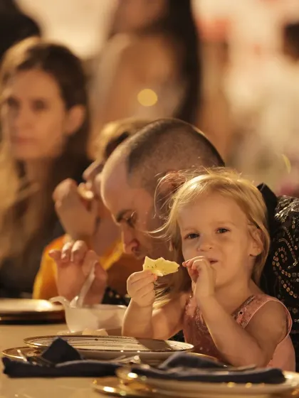 Even our youngest guests enjoy the experience. A child nibbles on a snack, comfortable and happy at an elegantly set table.