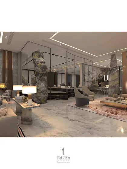 An expansive living area designed with multiple zones for relaxation and conversation. A massive natural rock sculpture acts as a powerful focal point, grounding the space and contrasting with the polished marble floors.