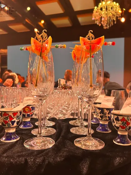 Elegance in every detail. Champagne flutes are pre-garnished with custom-branded skewers, ready for a toast, alongside unique ceramic shot glasses.
