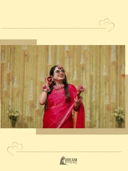 A candid shot of bride Ahana during her Haldi ceremony, looking joyful in her bright red saree and floral jewelry.