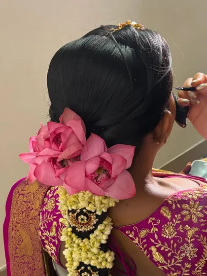 The delicate process of adding large, fresh lotus flowers to a bridal hairstyle. I handle fresh flowers with care to keep them vibrant.