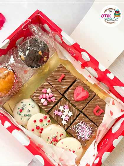 A Valentine's Day gift box filled with love. It includes "I ❤️ U" brownie bites, white chocolate-dipped cookies, and a chocolate cupcake.