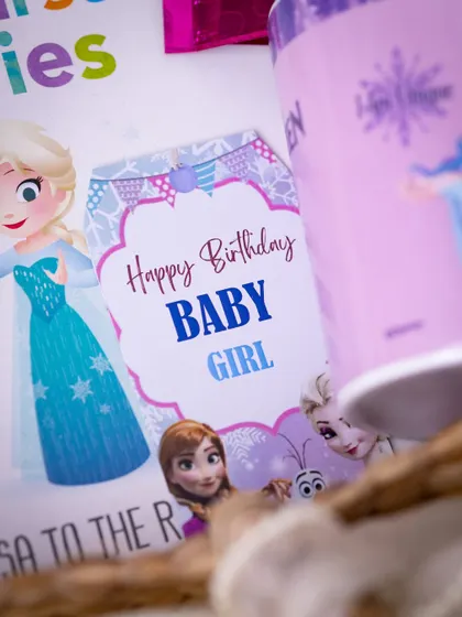 A custom 'Happy Birthday Baby Girl' tag with characters from 'Frozen', showing how I carry a theme through every detail of the hamper.