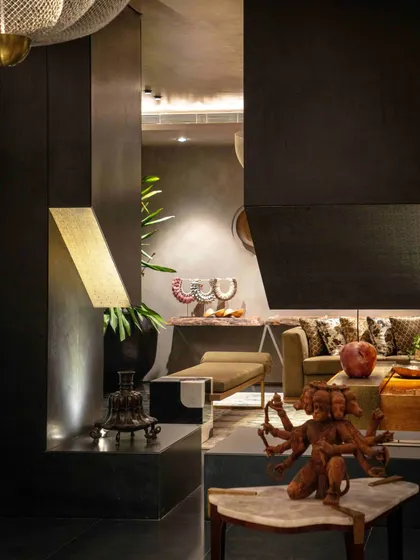 A detail shot showing a multi-armed deity sculpture on a marble-topped table. This vignette highlights our skill in placing unique, meaningful objects to create moments of artistic reflection.