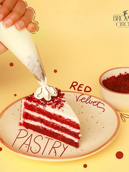 A perfect slice of my Red Velvet Pastry. You can see the distinct, moist layers of cake balanced with the light, tangy cream cheese frosting. Each slice is finished by hand with a sprinkle of red velvet crumbs.