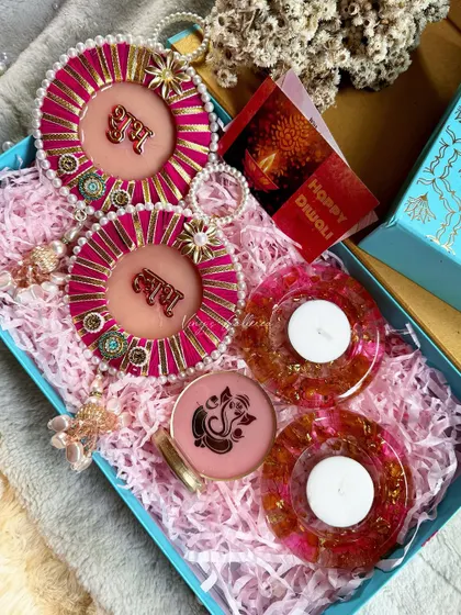 Another pink-themed Diwali hamper, this one with round tealight holders and "Shubh Labh" hangings.
