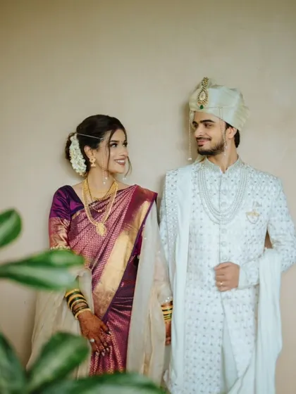 A classic portrait of a couple in elegant purple and white traditional wear.