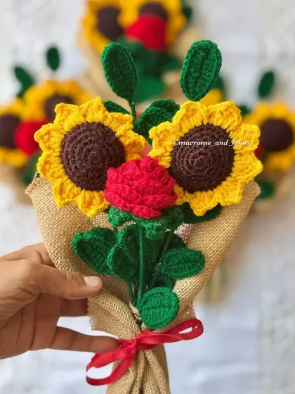 A close-up of the sunflower and rose bouquet, showing the vibrant colors and the careful construction of each crochet flower.