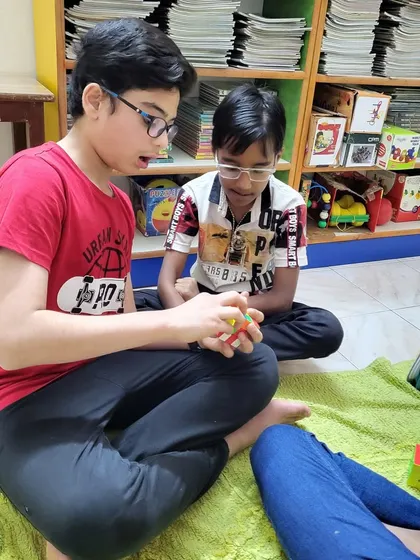 A fun Rubik's cube session in full swing! It’s amazing to see older kids mentoring the younger ones, sharing tips and tricks to solve the puzzle.