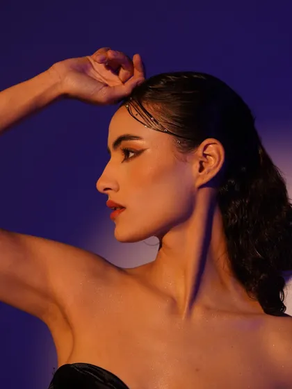 A classic profile portrait from the same series, showcasing the model's elegant neckline and the subtle, shimmering makeup details in her hair.