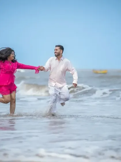 Running through the waves together. This playful shot from a Mumbai beach pre-wedding session is full of movement and happiness, perfectly capturing the couple's adventurous spirit.