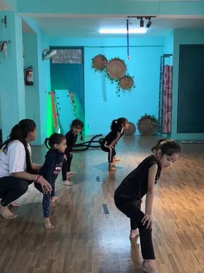 Guiding a young student in a basic dance stance. Correct posture is taught from the very first class.