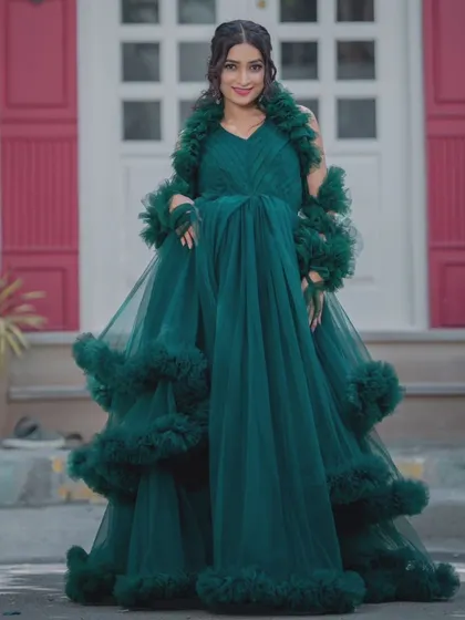 A full-length shot of our dramatic emerald green tulle gown with ruffled details. This rental is perfect for making a grand entrance.