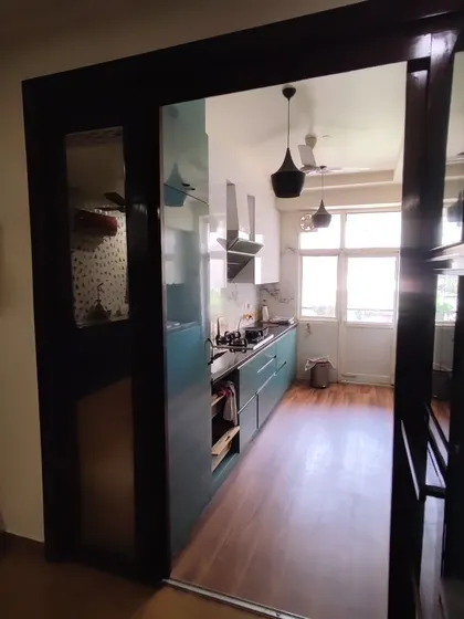 A view from the dining area into the parallel kitchen, showing how a sliding door can be used to separate the spaces when needed. This design maintains an open feel while providing the option for privacy.