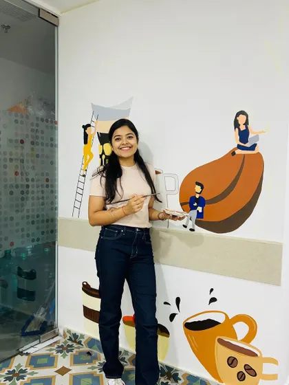 A smiling shot of me with the in-progress coffee mural. I love creating art that makes people happy.