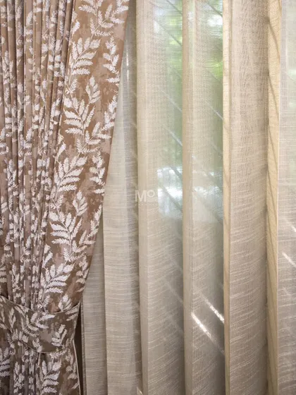 We bring timeless elegance to your windows by layering different textures. Here, a luxurious velvet blend drape with nature-inspired leaf motifs is paired with a lightweight sheer, allowing natural light to filter through while maintaining privacy in this DLF Phase 2 home.