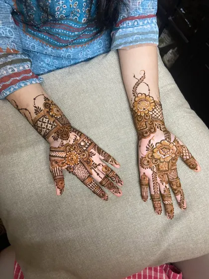 A view of two different henna designs side-by-side, one intricate and one Arabic floral style.