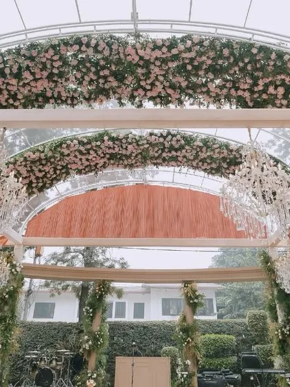 A custom-built transparent arched structure forms the ceiling of this reception venue. We lined the arches with pink flowers and hung crystal chandeliers for a spectacular effect.