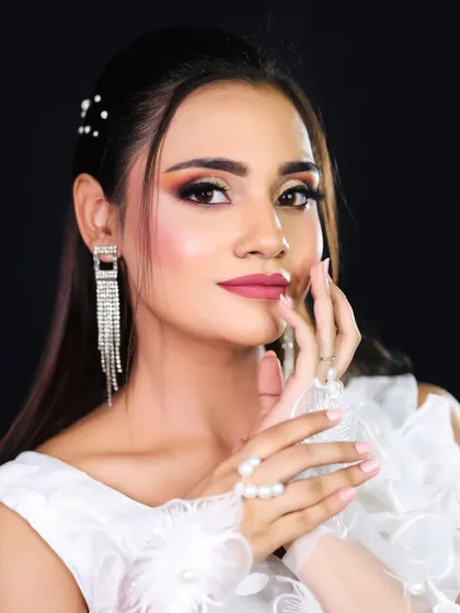 A close-up of the white-themed look, focusing on the warm, peachy eye makeup and glowing skin.