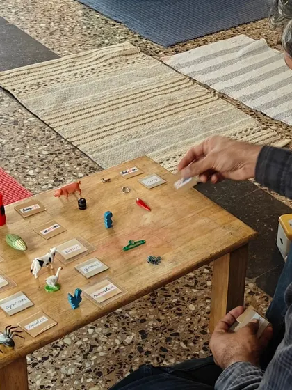 A parent engages in a language activity, matching miniature objects to their corresponding word labels. This demonstrates how we build a rich vocabulary and foundation for reading in a fun, interactive way.