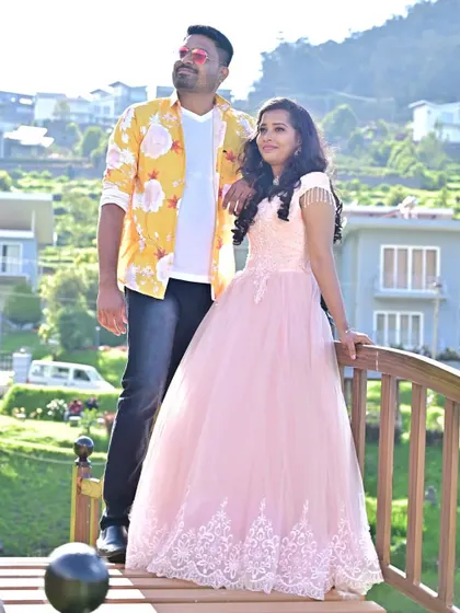 A stylish couple's portrait on a bridge. The client is wearing a lovely peach ball gown with lace details, perfect for a romantic and elegant pre-wedding shoot.