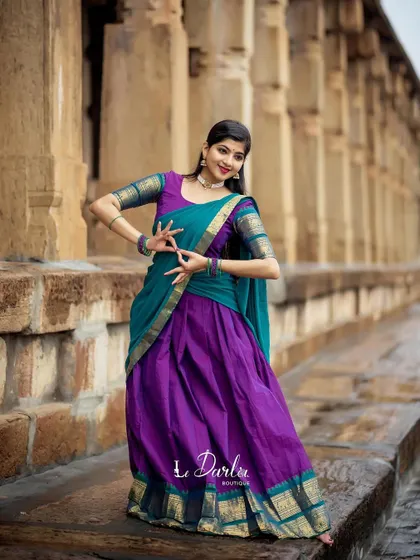 A series of photos from a collaboration with a designer, showcasing a beautiful half-saree against the backdrop of ancient temple pillars. I love how the vibrant colors of the costume stand out.