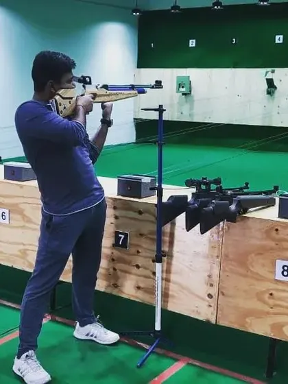 A student practices with an air rifle, using a stand for support. This helps beginners focus purely on aiming and trigger discipline.