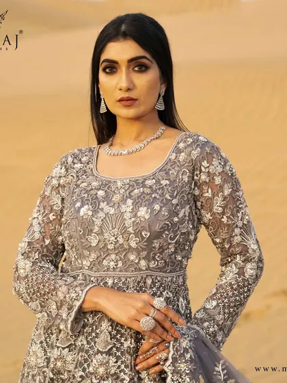 A close-up of the magnificent peach with coral peach Indo-Western Gown, showcasing the beautiful water-gold zardosi handwork.