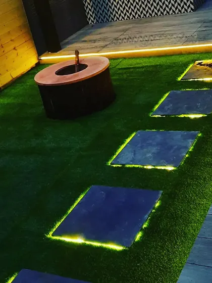 A close-up of the backlit stone pathway. The light escaping from the edges of the stones creates a magical, floating effect at night.